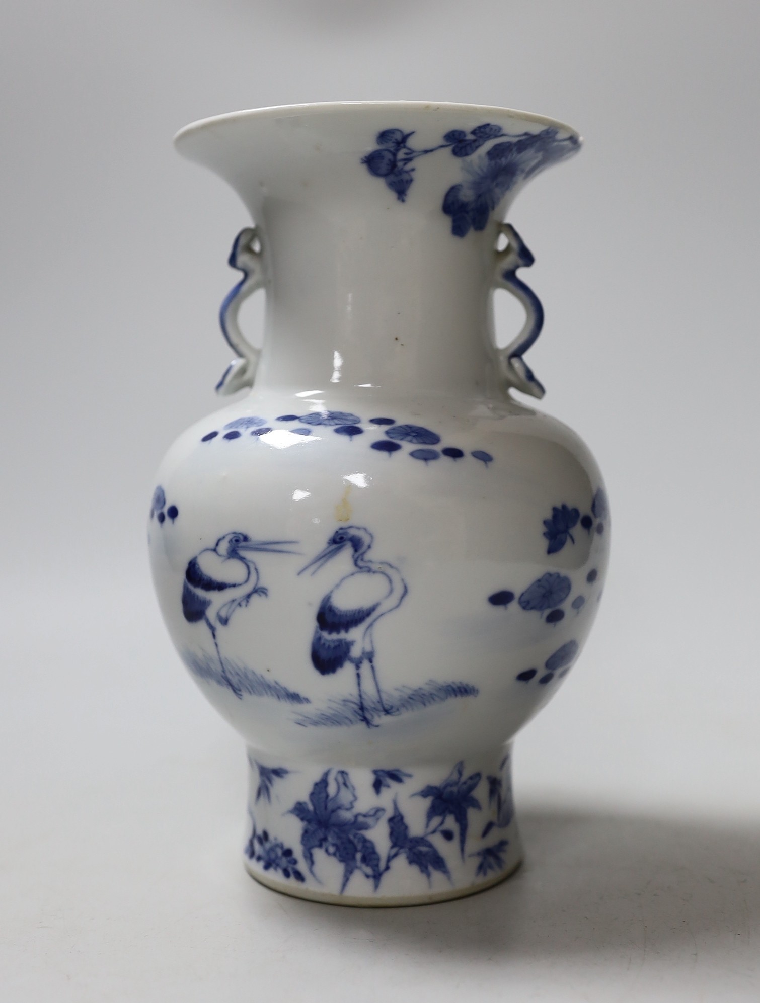 A small Chinese twin handled blue and white porcelain vase, Kangxi marks to underside, 19th century, 20cms high